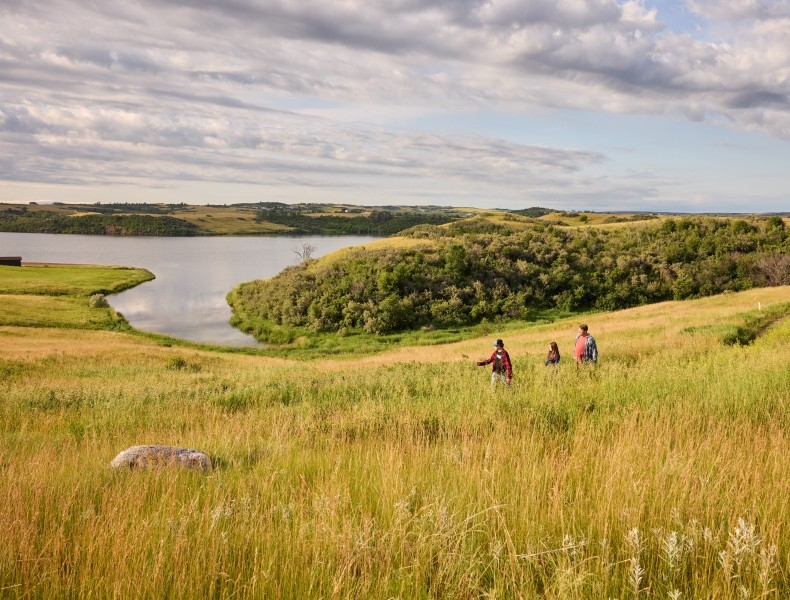 Family hiking along a lake trail.