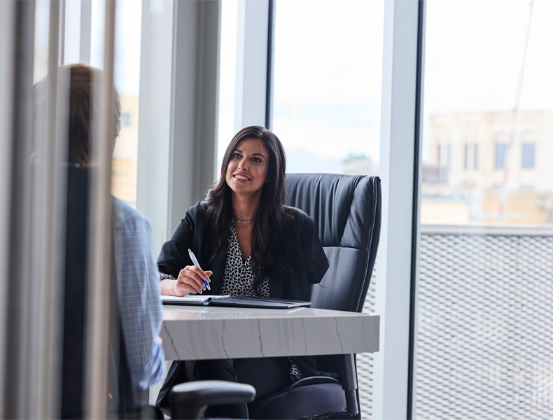 Woman behind a desk.